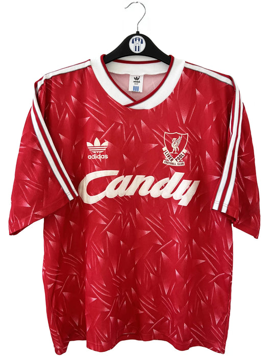 Maillot de foot vintage domicile de liverpool de la saison 1989/1991. Il s'agit du maillot domicile de couleur rouge et blanc. On peut retrouver l'équipementier adidas et le sponsor candy en feutrine. Il s'agit d'un maillot authentique d'époque.