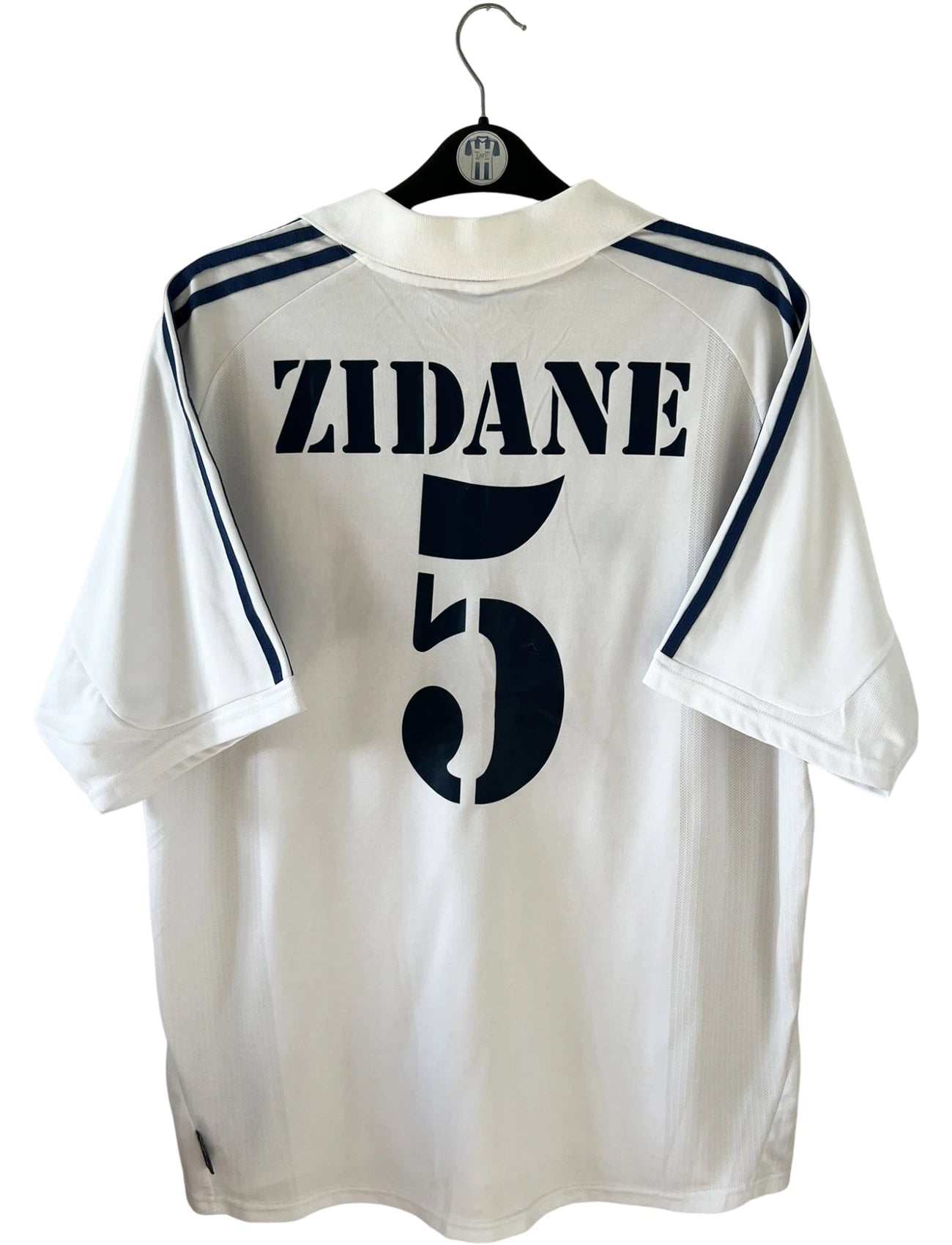 Maillot de foot vintage domicile blanc du Real Madrid 2001/2002. On peeut retrouver l'équipementier Adidas et le sponsor Real Madrid.com. Le maillot est floqué du numéro 5 Zinedine Zidane. Il s'agit d'un maillot authentique d'époque.
