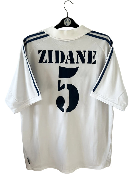 Maillot de foot vintage domicile blanc du Real Madrid 2001/2002. On peeut retrouver l'équipementier Adidas et le sponsor Real Madrid.com. Le maillot est floqué du numéro 5 Zinedine Zidane. Il s'agit d'un maillot authentique d'époque.