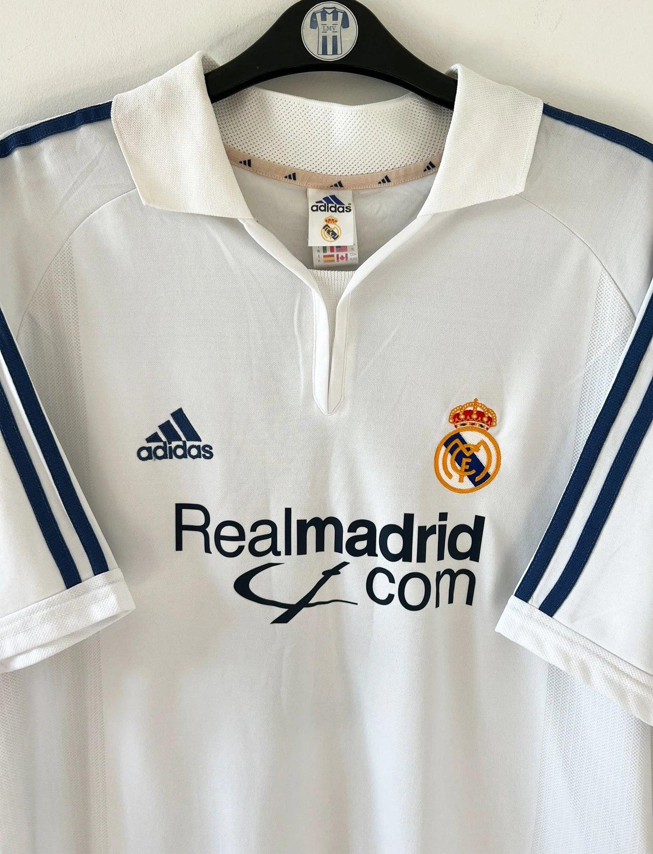 Maillot de foot vintage domicile blanc du Real Madrid 2001/2002. On peeut retrouver l'équipementier Adidas et le sponsor Real Madrid.com. Le maillot est floqué du numéro 5 Zinedine Zidane. Il s'agit d'un maillot authentique d'époque.