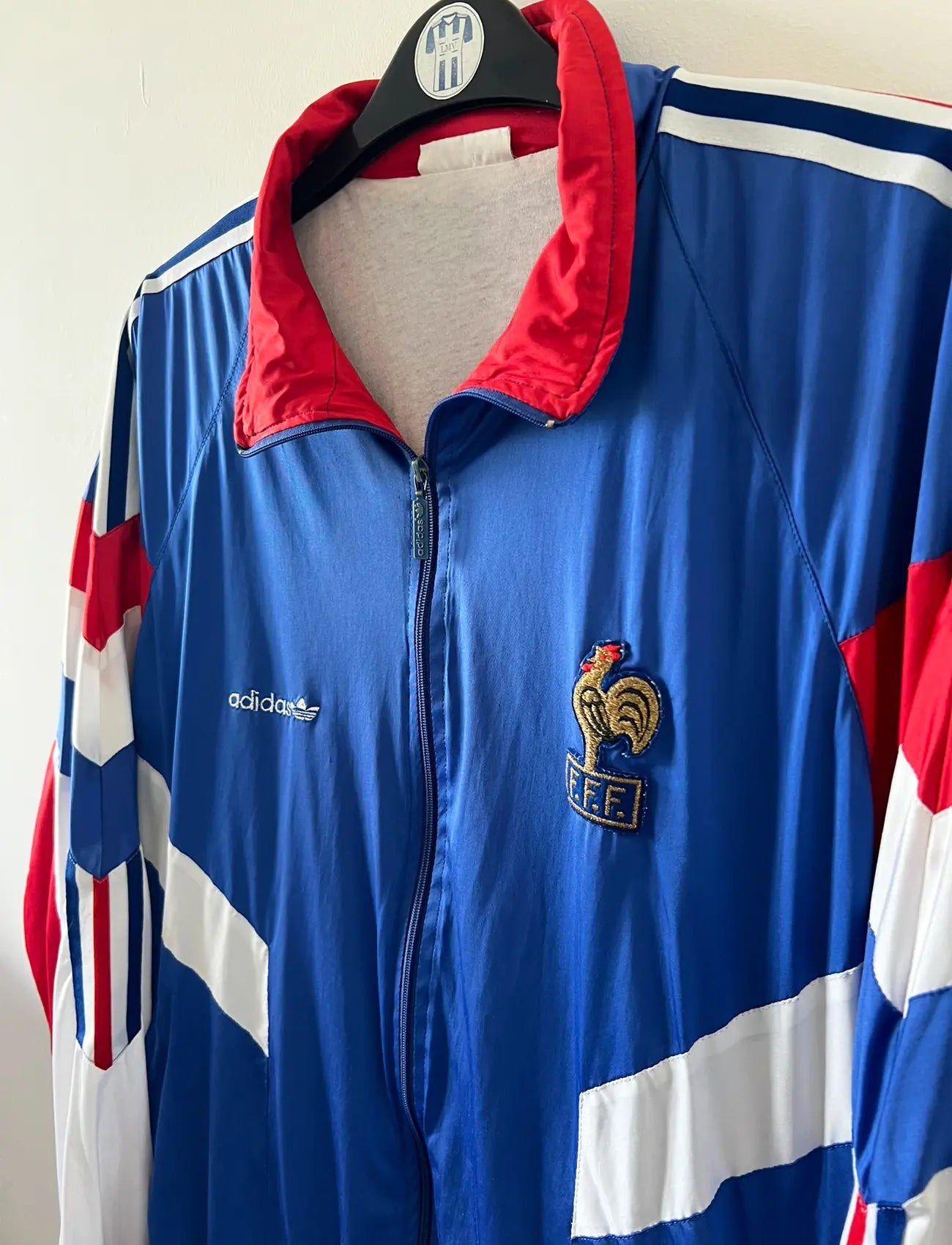 Veste foot vintage bleue de l'Equipe de France 1992. On peut retrouver l'équipementier Adidas. Il s'agit d'une veste authentique d'époque.