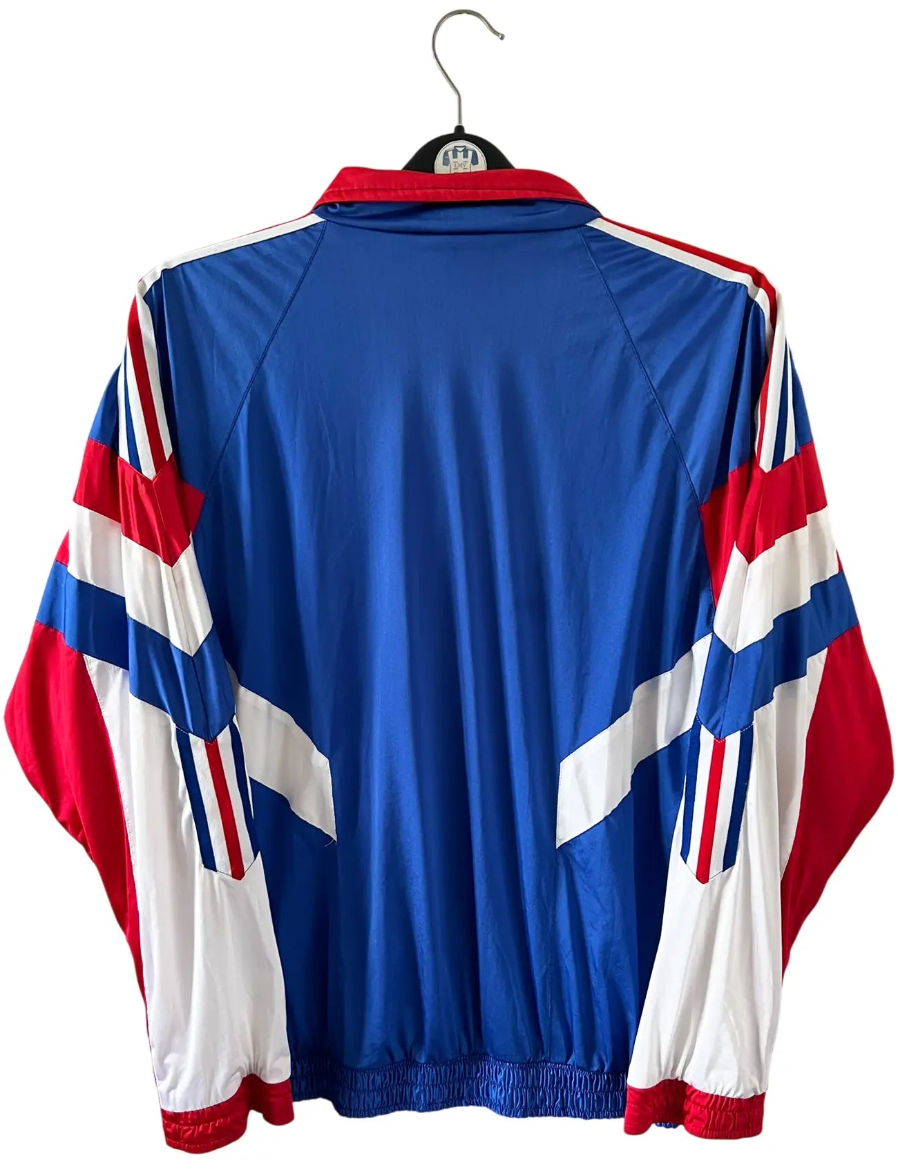 Veste foot vintage bleue de l'Equipe de France 1992. On peut retrouver l'équipementier Adidas. Il s'agit d'une veste authentique d'époque.