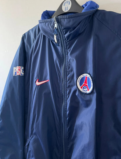 Veste de foot vintage bleue du PSG 1997/1998. On peut retrouver l'équipementier Nike. Il s'agit d'une veste authentique d'époque.