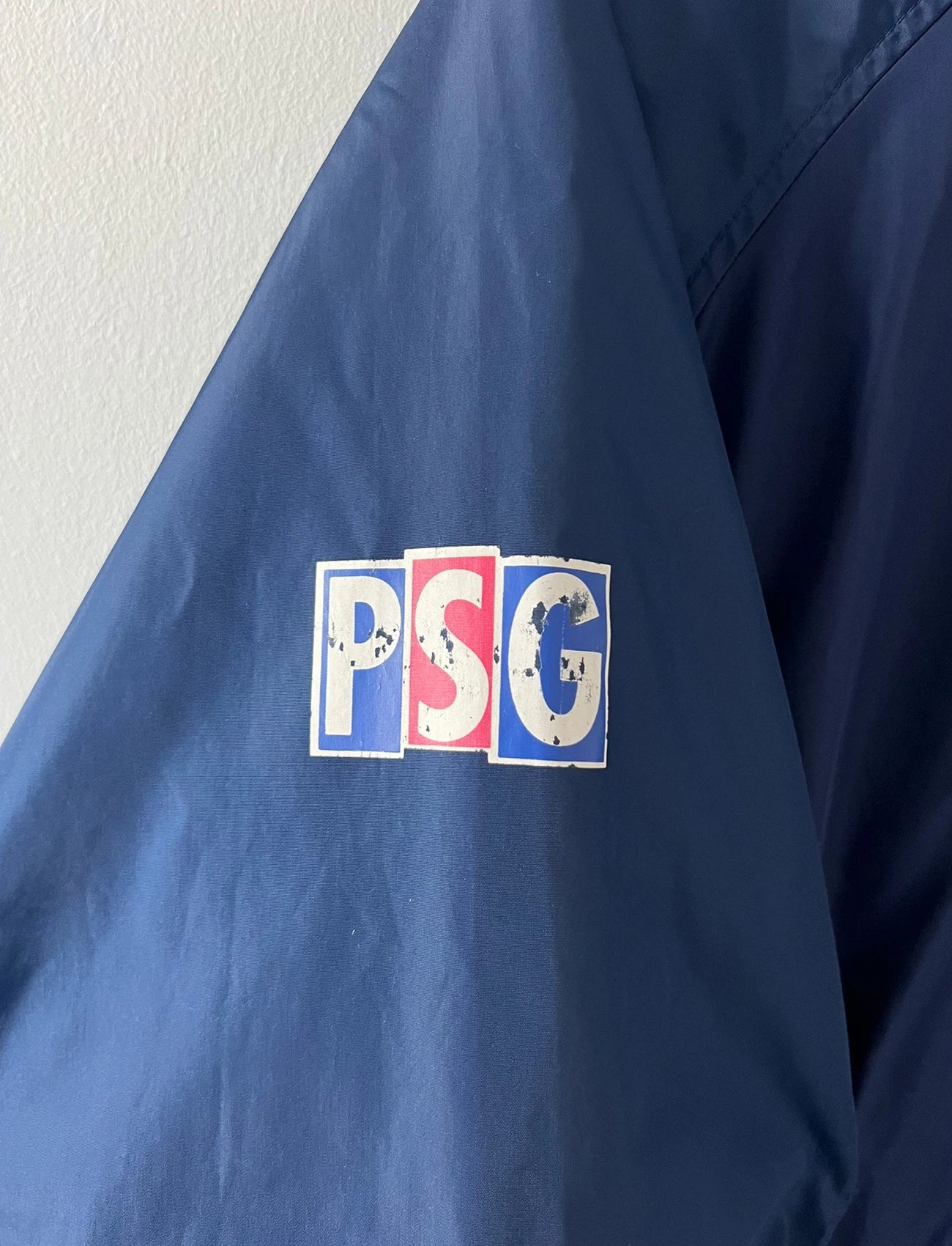 Veste de foot vintage bleue du PSG 1997/1998. On peut retrouver l'équipementier Nike. Il s'agit d'une veste authentique d'époque.