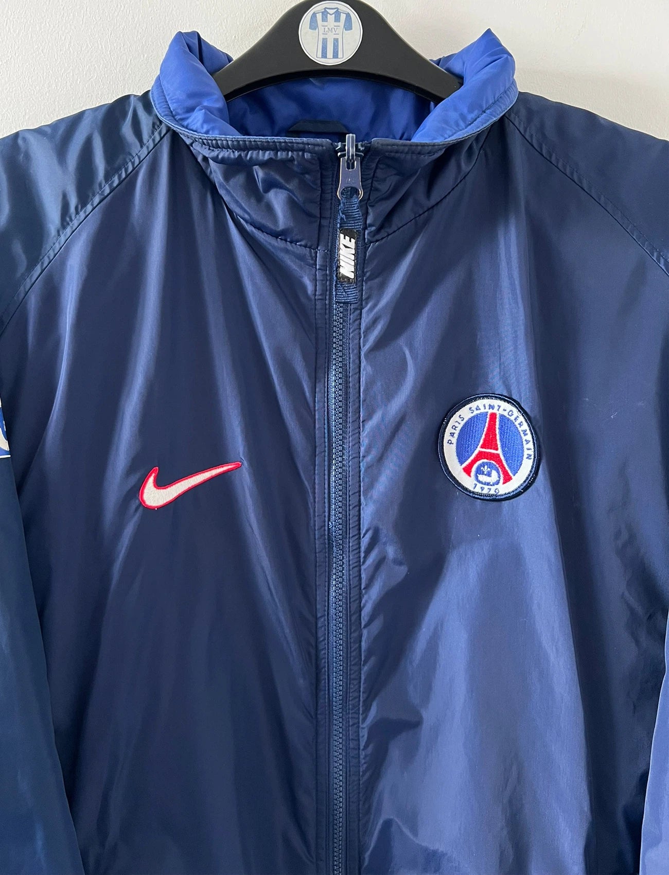 Veste de foot vintage bleue du PSG 1997/1998. On peut retrouver l'équipementier Nike. Il s'agit d'une veste authentique d'époque.