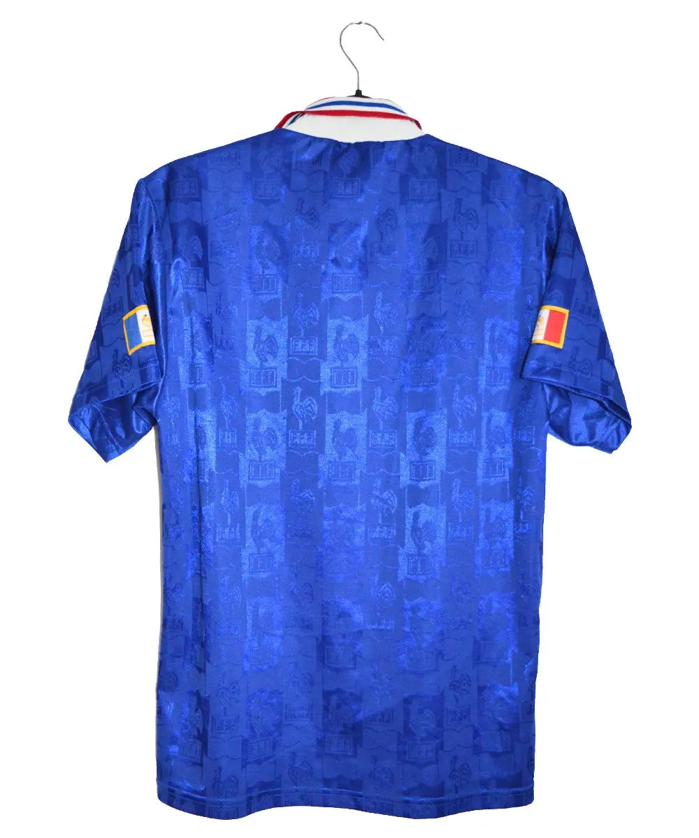 Maillot de foot retro authentique de l'équipe de france 1996. Le maillot est au couleur de la france (bleu, blanc, rouge). Des motifs de coqs sont brodés dans le maillot. On retrouve aussi l'équipementier adidas