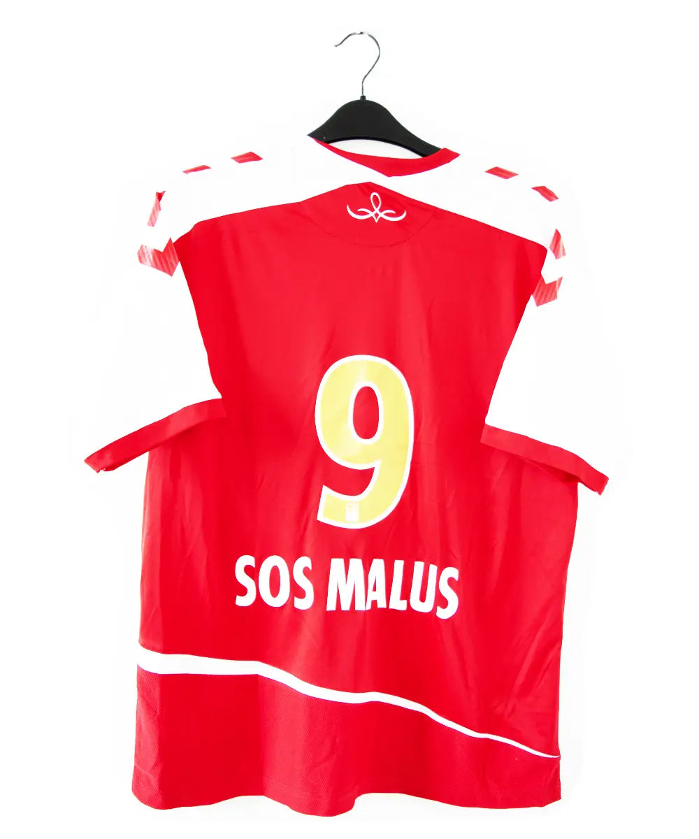 Maillot domicile du stade de reims de la saison 2015-2016. Le maillot est de couleur rouge et blanche. On peut retrouver le sponsir sanei ascenseur, le sponsor caillot, le sponsor geodis et l'équipementier hummel