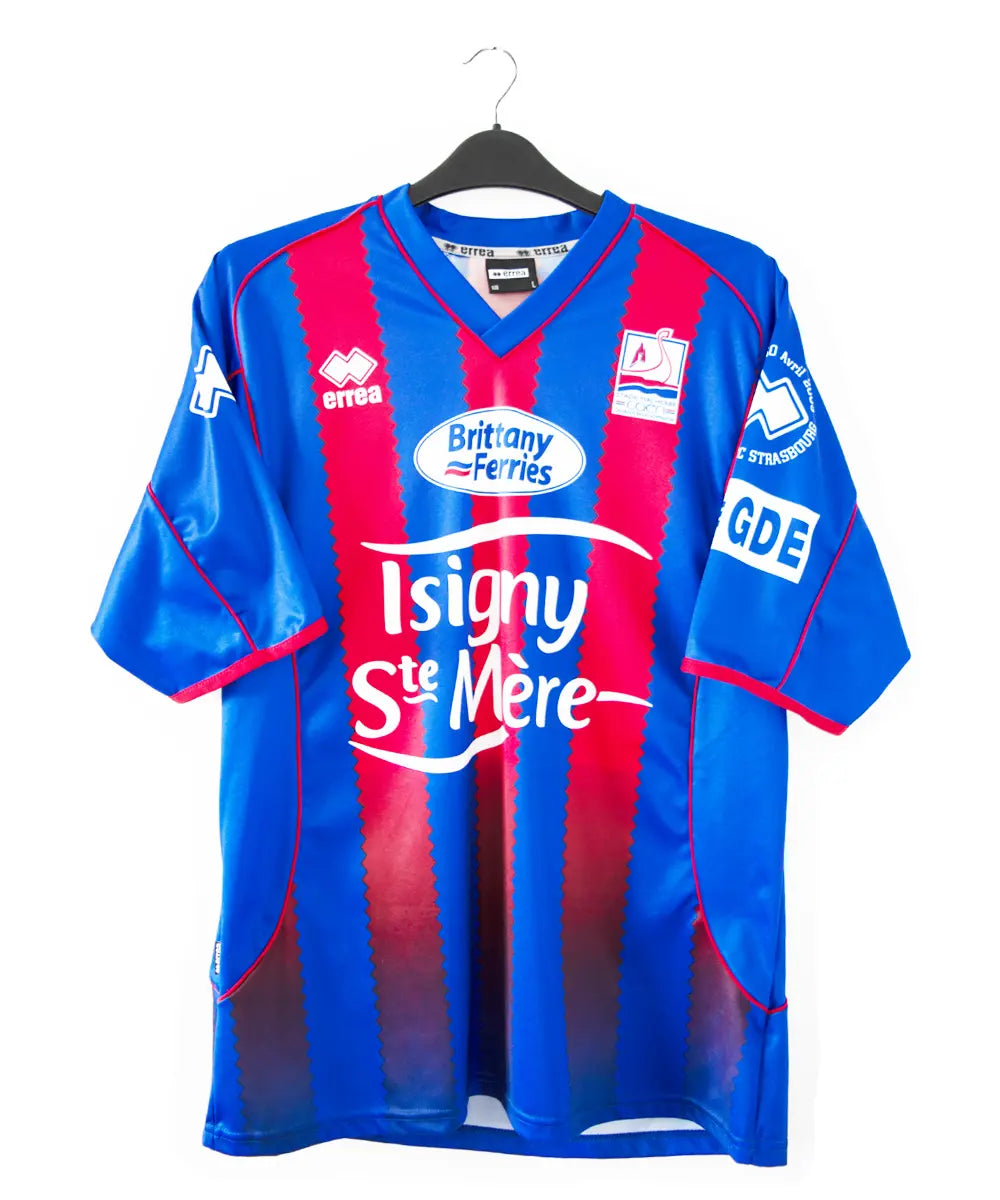 Maillot domicile du SM Caen édité lors de la finale de la coupe de la ligue face à Strasbourg. Le maillot est de couleur rouge et bleu. On peut retrouver la date de la finale, l'équipementier errea et le sponsor phillips