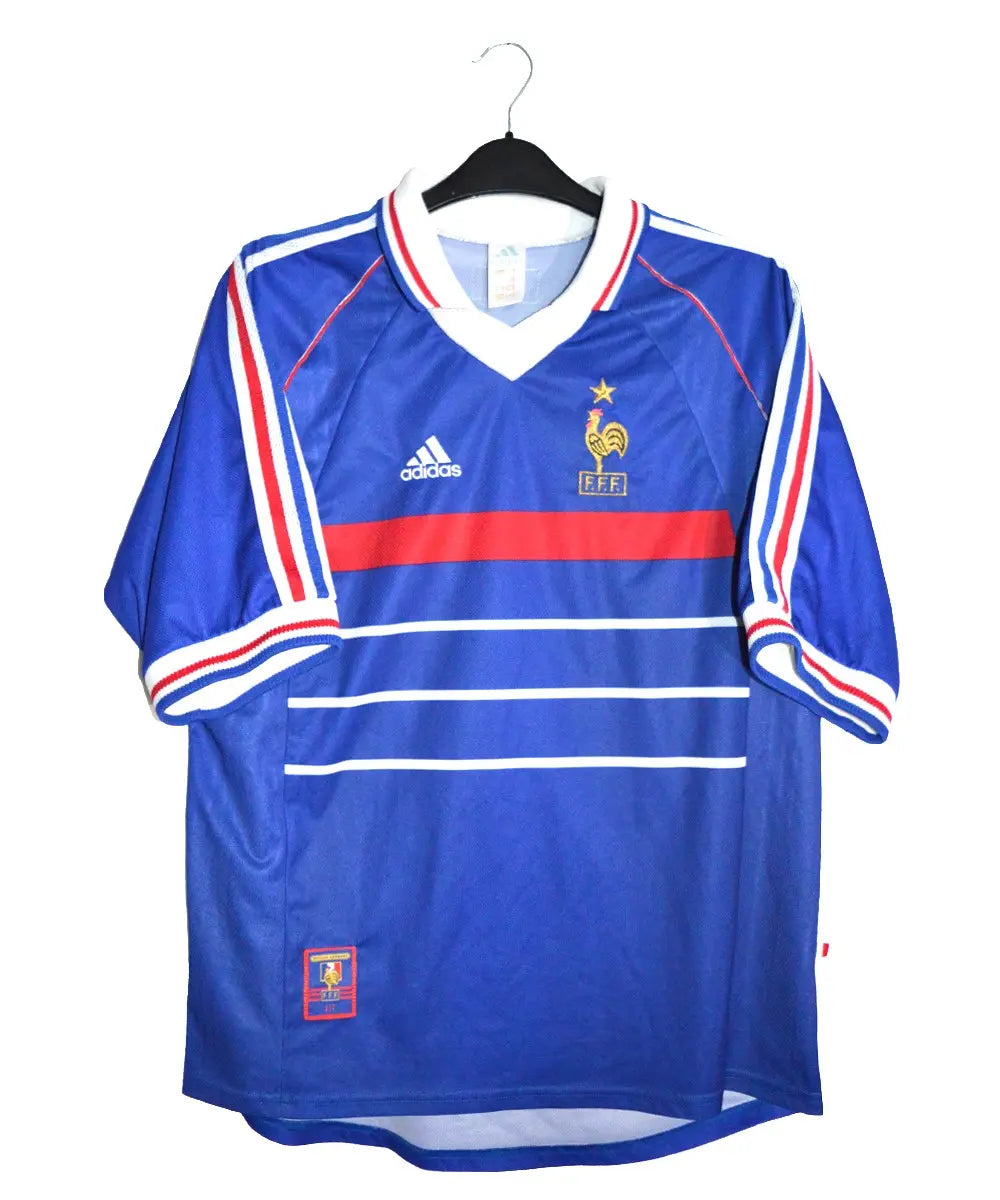 Maillot de foot retro/vintage authentique domicile de l'équipe de france 1998. De couleur bleu et rouge, on peut retrouver l'équipementier adidas et l'étoile sur le coq.