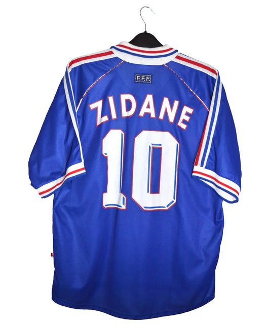 Maillot domicile bleu de l'équipe de france 1998. Le maillot est floqué Zinedine Zidane. On peut retrouver l'équipementier adidas sur le maillot