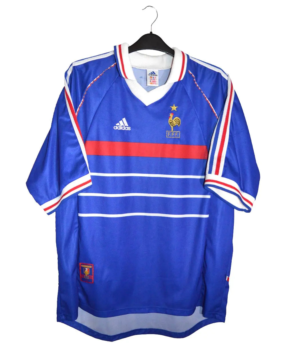 Maillot domicile bleu de l'équipe de france 1998. Le maillot est floqué Zinedine Zidane. On peut retrouver l'équipementier adidas sur le maillot