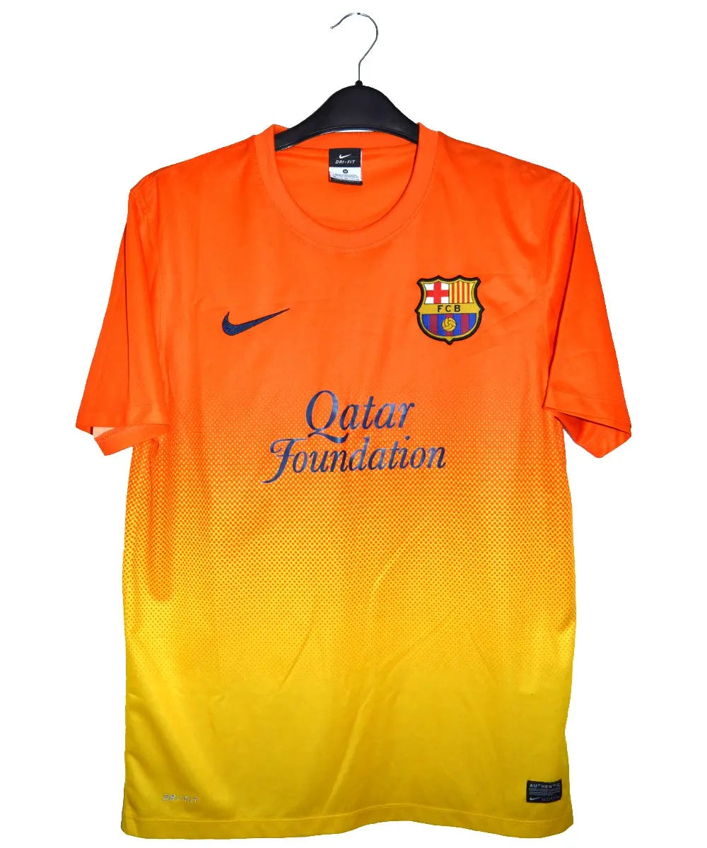 Maillot orange et jaune du FC Barcelone porté lors de la saison 2012-2013. On peut retrouver l'équipementier nike et le sponsor qatar foundation