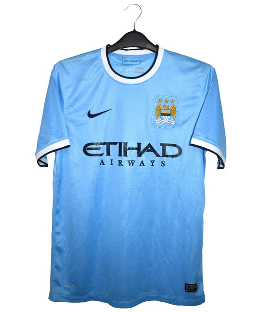 Maillot domicile porté par manchester city lors de la saison 2013-2014. On peut retrouver l'équipementier nike et le sponsor etihad